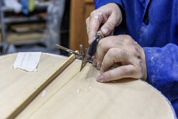 Luthier carefully installing purfling on handmade flamenco guitar body