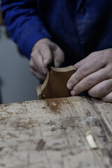 Luthier shaping guitar headstock with hand file