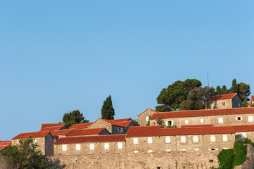 Sveti Stefan Island Hotel, stone houses of a medieval fortress village with tiled roofs on the Adriatic coast of Montenegro