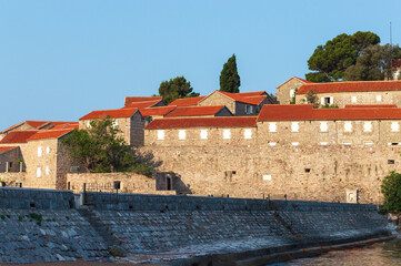 Sveti Stefan Island Hotel, stone houses of a medieval fortress village with tiled roofs on the Adriatic coast of Montenegro