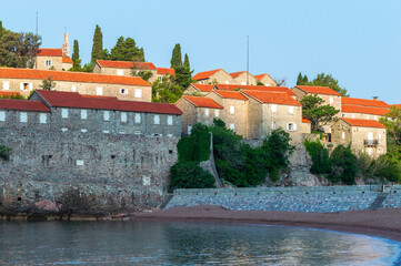 Sveti Stefan Island Hotel, stone houses of a medieval fortress village with tiled roofs on the Adriatic coast of Montenegro