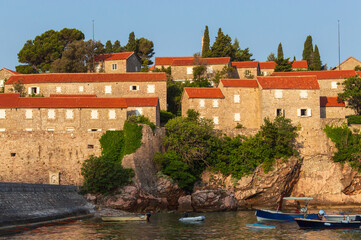 Sveti Stefan Island Hotel, stone houses of a medieval fortress village with tiled roofs on the Adriatic coast of Montenegro
