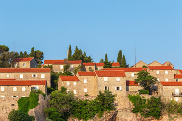 Sveti Stefan Island Hotel, stone houses of a medieval fortress village with tiled roofs on the Adriatic coast of Montenegro