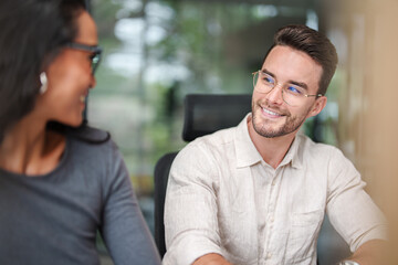 Young Adult Male and Asian Woman Collaborating in a Bright Modern Workspace
