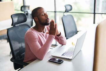 Fototapeta premium Black Young Adult in Pink Sweater Working in Contemporary Office with Laptop and Smartphone