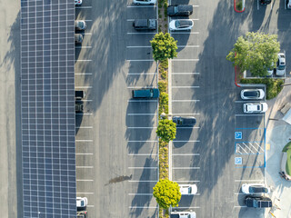 Aerial view of solar panels installed as shade roof over parking lot for parked cars. Photovoltaic technology integrated in urban infrastructure. High quality photo