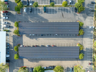 Aerial view of solar panels installed as shade roof over parking lot for parked cars. Photovoltaic technology integrated in urban infrastructure. High quality photo