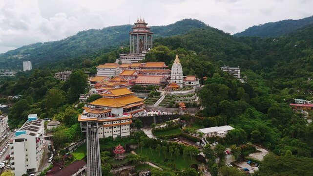 Kek lok si temple rising on penang hill, featuring ornate buddhist pagoda and stupa surrounded by lush tropical landscape