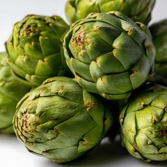 Obraz premium Close up of multiple fresh green artichokes on white background
