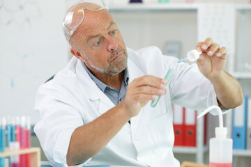 senior male scientist using pipette