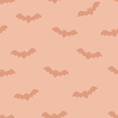 Cute flying bat silhouette seamless vector pattern in soft orange tones for Halloween or autumn decor