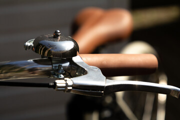 A classic metal bike bell mounted on the handlebar, symbolizing vintage charm and functional...