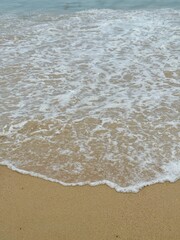 Gentle Waves of the Andaman Sea Washing Over Sandy Beach in Phuket, Thailand