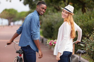 happy funny young couple riding on bicycle