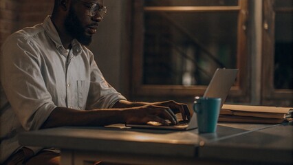 Young man working on laptop at home or office setting
