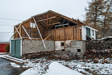 Partially collapsed wooden barn with snow.
