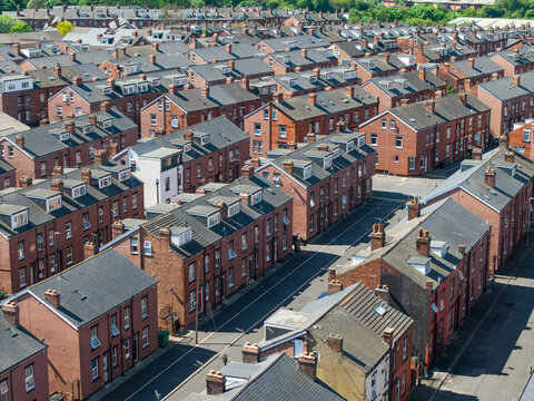 Aerial view above rows of back to back terraced houses on a large council estate
