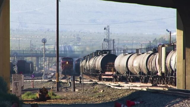 A freight train of oil tanker cars and hoppers moves through the railyard in Mojave, California.