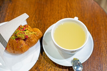 fresh croissant with raspberries and pistachio cream and ginger tea. Good morning