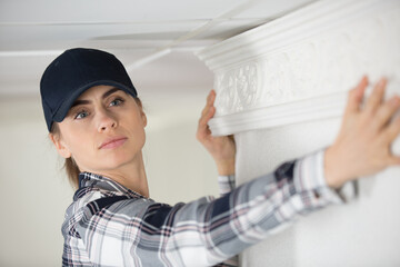 female plasterer painter at indoor wall renovation decoration