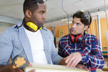 2 wood workers talking in studio