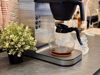 Introducing a sleek Coffee Maker with a glass carafe and modern design for any kitchen. A stylish and sleek coffee maker that features a glass carafe and an elegant design, ideal