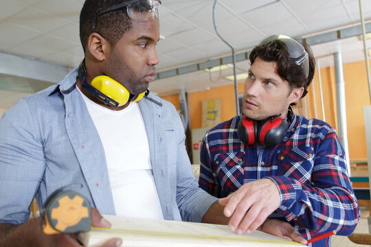2 wood workers talking in studio