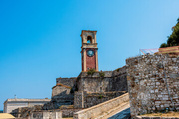 The iconic clock tower of the Old Fortress in Corfu, Greece, standing proudly against a clear blue...