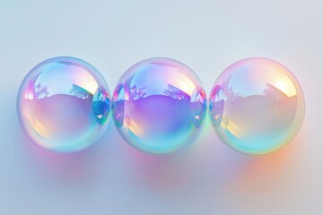 Three iridescent soap bubbles resting side by side, showing pastel colors and mesmerizing reflections, on a smooth, light gray background.