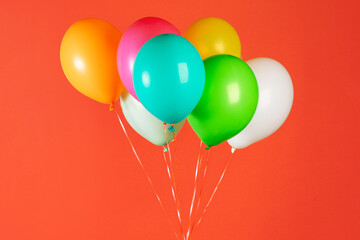 Children's party colorful balloons against orange background. Valentines day or birthday party concept.