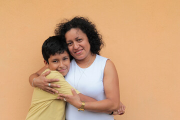 A divorced single mother and her 9-year-old Latino son show their love with hugs and kisses to celebrate Mother's Day