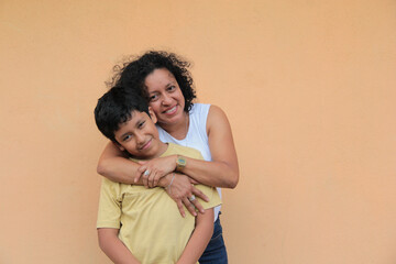 A divorced single mother and her 9-year-old Latino son show their love with hugs and kisses to celebrate Mother's Day