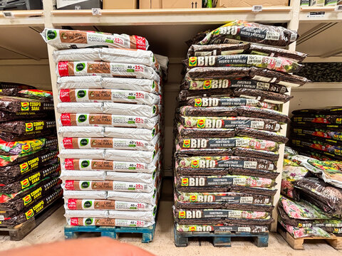Alicante, Spain - June 18, 2025: Stacked bags of organic fertilizer in a garden supply store, showcasing various brands and types, ideal for gardening enthusiasts and eco-friendly practices