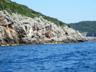 Turquoise Adriatic Waters Embrace Rugged Cliffs of Montenegro on a Sunny Day