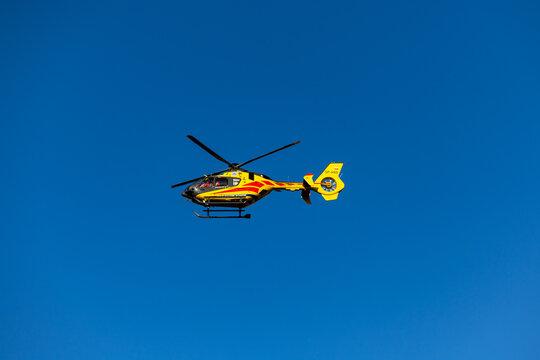 Grodzisk Mazowiecki, Masovian Voivodeship, Poland. December 3, 2024. Yellow LPR helicopter flying against the blue sky during a rescue mission.