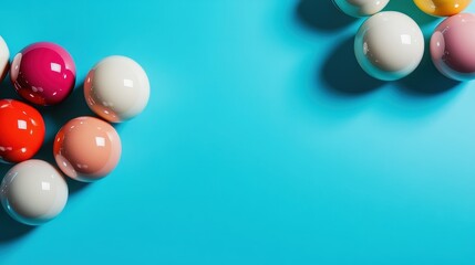 A collection of shiny, vibrant balls in various colors rests playfully on a bright blue background, creating an inviting and lively atmosphere in an abstract composition.