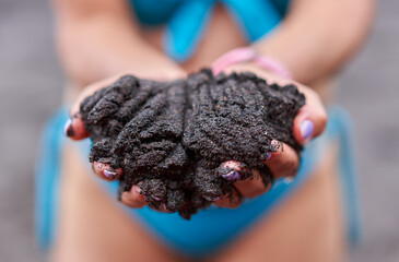 Woman holding volcanic beach sand