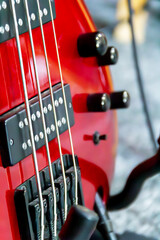Close up view of a vibrant red electric guitar featuring detailed strings and controls