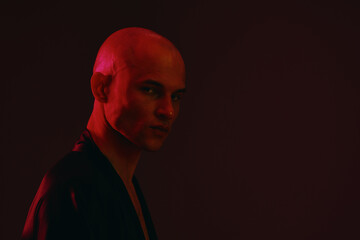 Intense man in a moody black and white shot, showcasing a strong presence and deep emotion with dramatic lighting and shadows.