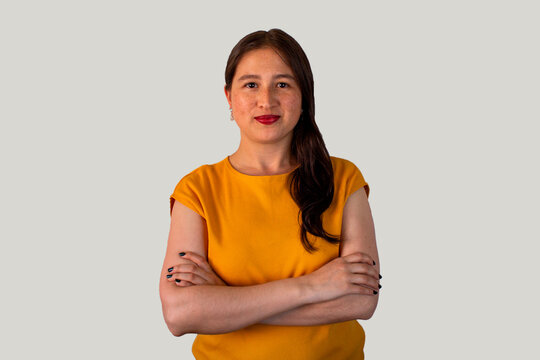 Profesionalidad femenina: retrato de mujer joven con brazos cruzados y blusa amarilla.