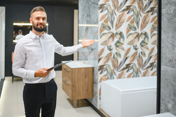 Portrait of seller in bathroom store. Happy man works in bath store. Sales occupation