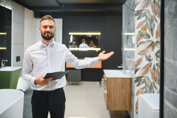 Portrait of seller in bathroom store. Happy man works in bath store. Sales occupation