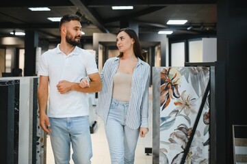 Young couple choosing tiles at building market