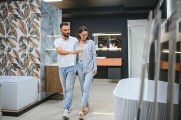 Young family couple choosing bathroom sink in bathroom fixtures store