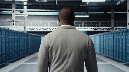 System administrator in data center doing inspection on infrastructure tech handling user requests....