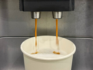Milk is whipped for cappuccino. Making coffee by coffee machine into paper cup, latte coffee coming...