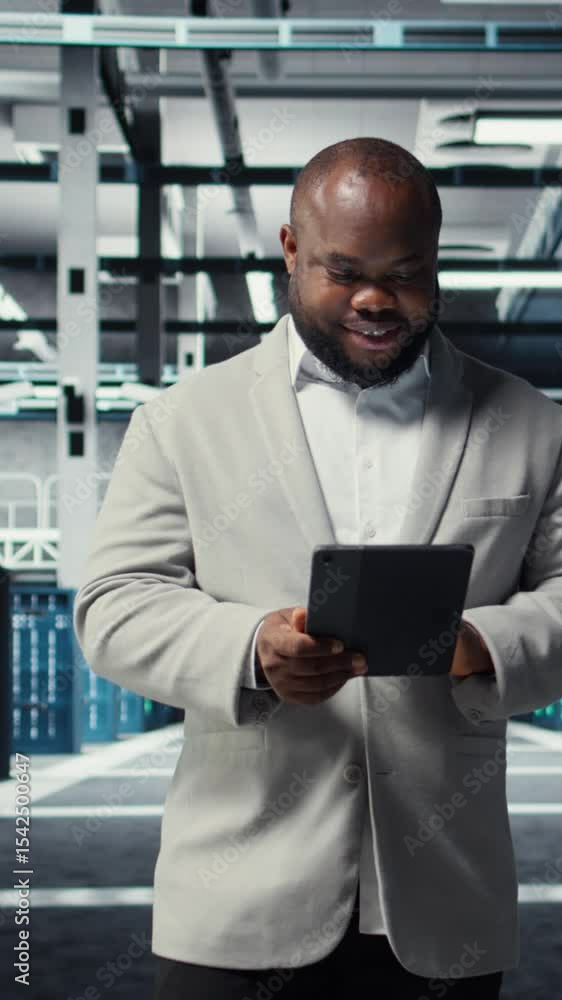 Poster vertical video happy engineer walking in data center refining algorithms on tablet for faster proces