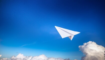 a paper airplane soaring through the blue sky symbol of freedom dreams and travel