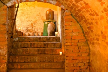 A view of an old cellar and old stoneware jars. Old basement stairs and stoneware jars for storing food. The concept of food storage and preservation in the past