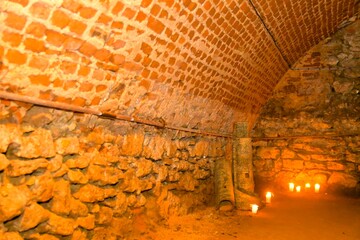 A view of old corridors lit by candles. Old cellar spaces lit by candles. The concept of romance and old times